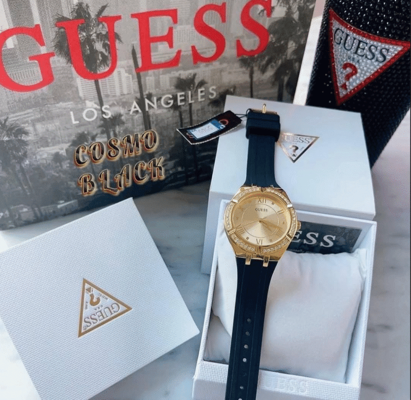 Gros plan du cadran doré soleillé et de la lunette ornée de cristaux clairs de la montre GUESS GW0034L1.