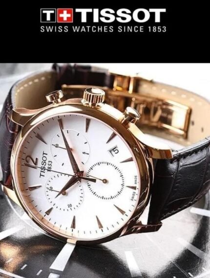 Marque: TISSOT Modèle: Tradition Boîtier: Diamètre : 42 mm Epaisseur : 11.1 mm Acier inoxydable Doré Cadran: Verre : Minéral Blanc Bracelet: Largeur : 20 mm Cuir Marron Etanchéité: 30 m (3 ATM) Type de boucle: Boucle déployante Détails techniques: Dateur Chronomètre