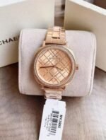 Marque: Michael Kors Modèle: NIA Boîtier: Diamètre : 38 mm Epaisseur : 8 mm Acier inoxydable Bronze Cadran: Verre : Minéral Bronze Bracelet: Acier inoxydable Bronze Etanchéité: 50 m (5 ATM) Type de boucle: Boucle déployant