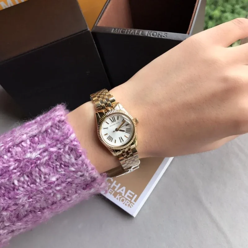 Guide 2026 : Quelles sont les tendances actuelles pour les montres féminines ? Montre Michael Kors Lexington Mini MK3229 dorée portée au poignet pour montrer sa taille de 26mm.