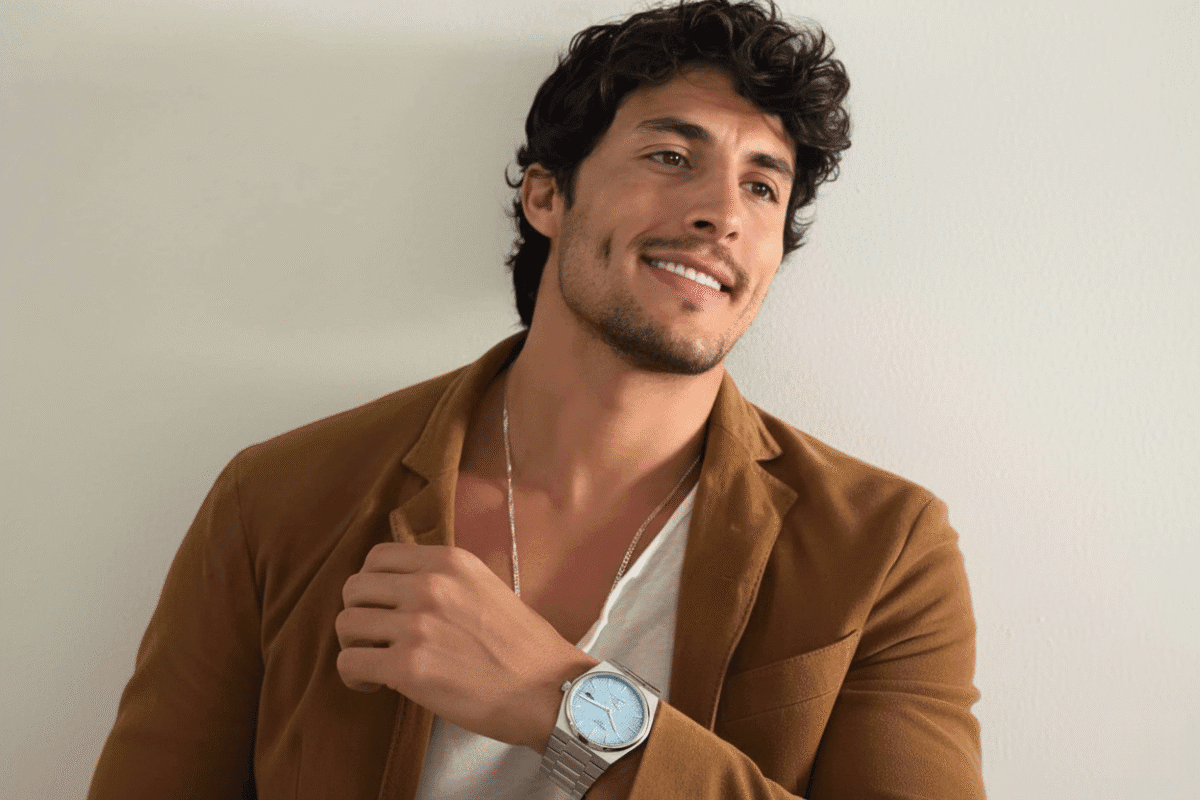 Le Guide Ultime pour Bien Choisir sa Montre Homme au Maroc Homme marocain élégant avec une veste marron portant une montre automatique de style Tissot PRX au poignet.
