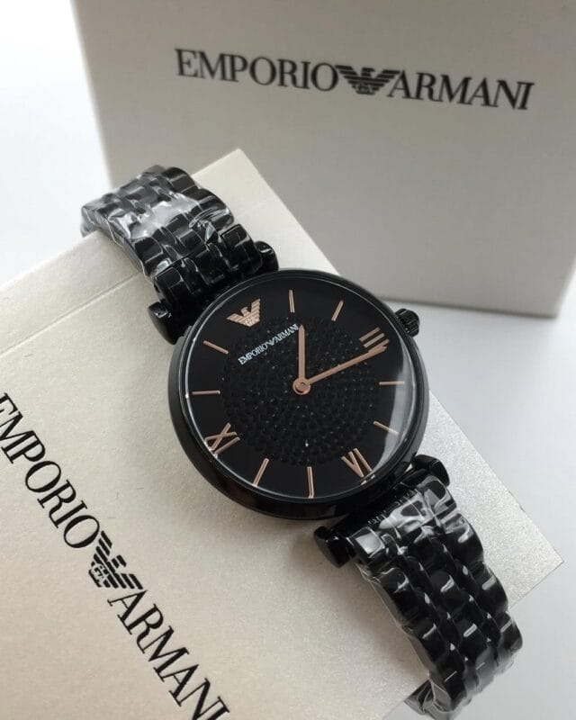 Guide 2026 : Quelles sont les tendances actuelles pour les montres féminines ? Détail de la montre acier noir femme Armani AR11245 posée sur sa documentation au Maroc.