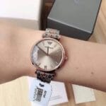 Montre Armani AR1840 Maroc (32mm) bicolore or rose portée au poignet par une femme.