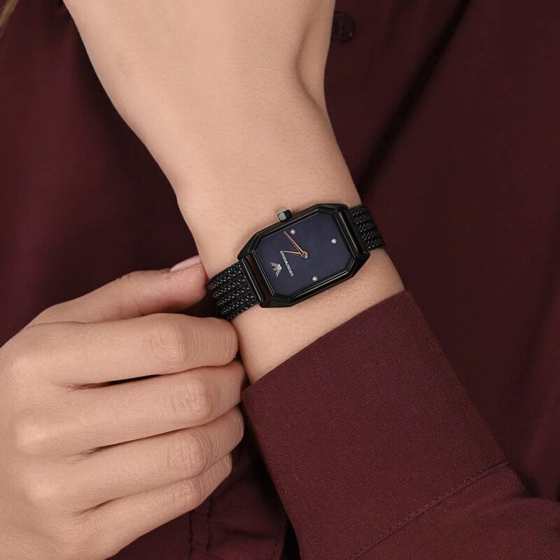 Guide 2026 : Quelles sont les tendances actuelles pour les montres féminines ? Montre femme rectangulaire AR11271 noire portée au poignet pour montrer sa petite taille au Maroc.