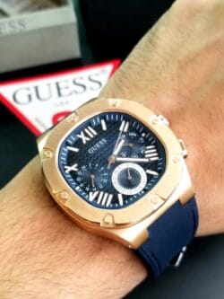 Montre Guess Headline GW0571G2 bleue et or rose portée au poignet d'un homme au Maroc.