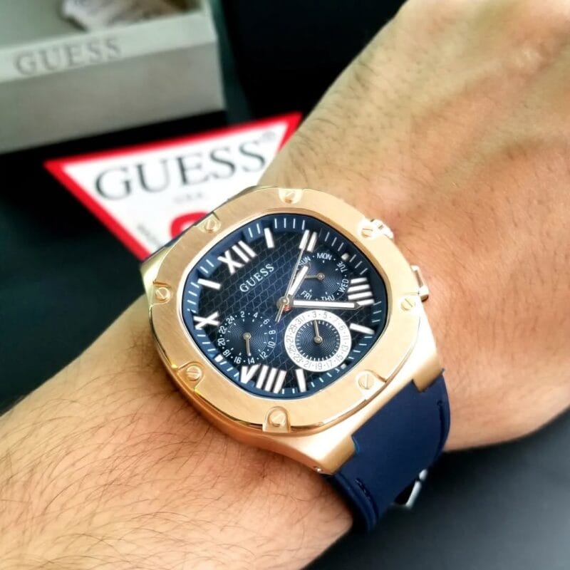 Montre Guess Headline GW0571G2 bleue et or rose portée au poignet d'un homme au Maroc.