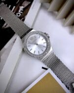 Montre femme tendance cristaux MK7337 (37mm) argentée en situation, posée sur un magazine au Maroc.