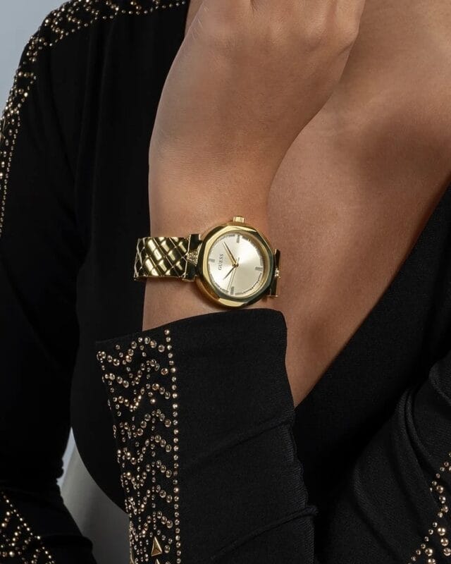 Vue rapprochée de la montre Guess femme dorée bracelet texturé GW0613L2 (34mm) sur un poignet, montrant les détails au Maroc.