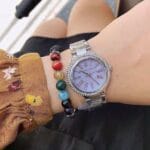 Montre Michael Kors MK6562 accessoirisée avec des bracelets colorés.