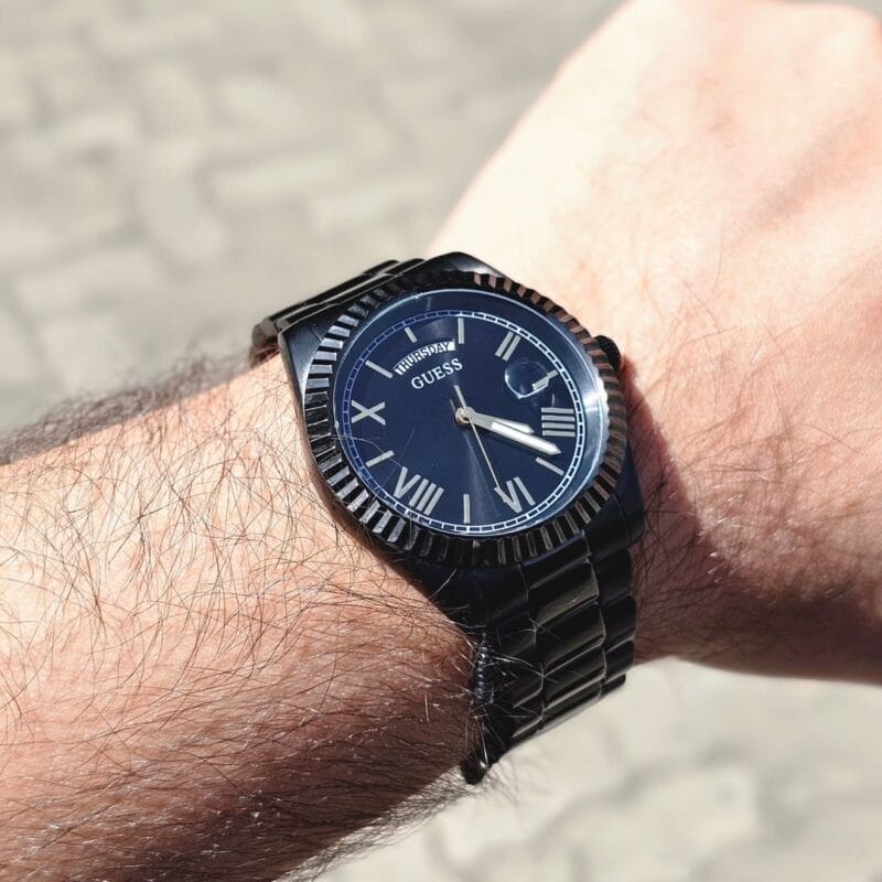 Montre Guess GW0265G4 portée au poignet avec un costume.