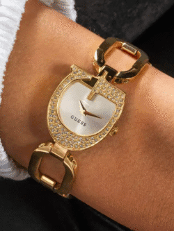 Montre-bijou GUESS GW0683L2 dorée avec cristaux portée élégamment au poignet d'une femme.