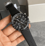 Montre Emporio Armani AR11243 tenu en main cadran noir tachymetre ceramique