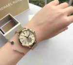 Montre Michael Kors MK3844 dorée pour femme portée au poignet