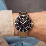 Montre Emporio Armani AR11680 portée au poignet d'un homme, boîtier acier 43 mm et bracelet bicolore argenté doré