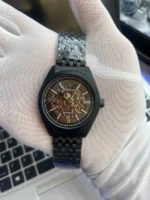 Montre homme Emporio Armani AR60093 automatique à cadran skeleton noir tenue dans une main gantée