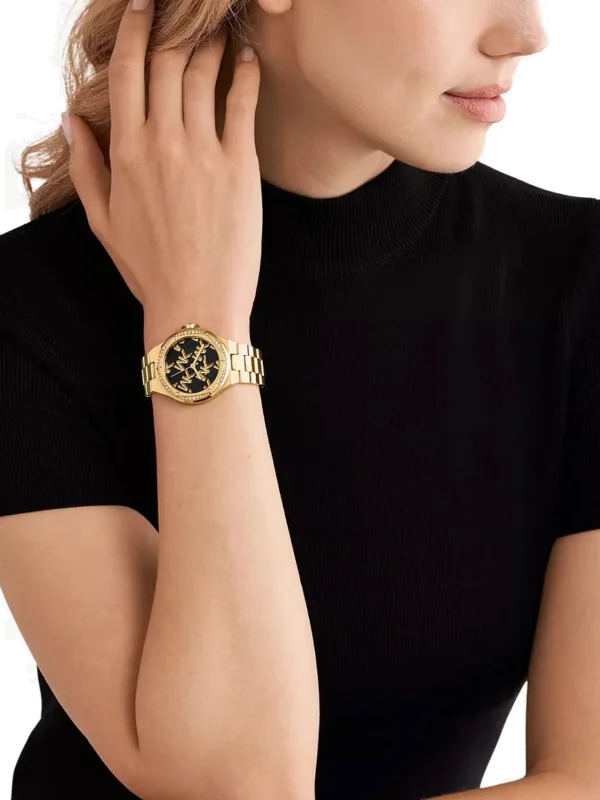 Michael Kors MK7404 portée au poignet d'une femme, bracelet doré et cadran noir élégant