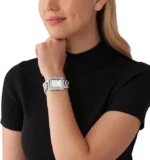 Montre Michael Kors MK7438 portée au poignet d'une femme avec son bracelet gourmette acier argenté style manchette bijou