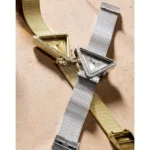 Montre Guess GW0508L1 Fame femme argentée posée à côté de la version dorée, boîtiers triangles sertis de cristaux