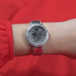 Montre Guess GW0528L1 Lily femme portée au poignet, cadran fleuri scintillant et bracelet acier argenté