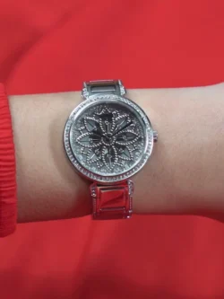 Montre Guess GW0528L1 Lily femme portée au poignet, cadran fleuri scintillant et bracelet acier argenté