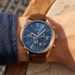 Montre Hugo Boss 1513817 portée au poignet, mettant en valeur son bracelet en cuir marron perforé et son cadran bleu
