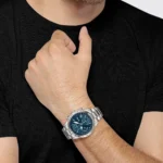 Montre Hugo Boss 1513850 portée au poignet par un homme en t-shirt noir, cadran bleu et bracelet acier