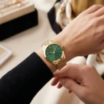Montre Michael Kors MK3435 Slim Runway femme portée au poignet, cadran vert et bracelet acier doré