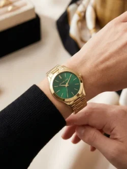 Montre Michael Kors MK3435 Slim Runway femme portée au poignet, cadran vert et bracelet acier doré