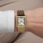 Petite montre Michael Kors Emery MK4826 dorée portée élégamment au poignet d'une femme