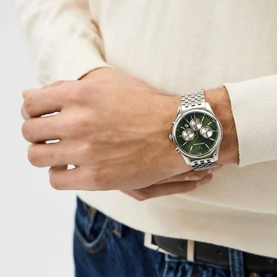 Montre Emporio Armani AR11581 portée au poignet d'un homme en pull crème, cadran vert et bracelet en acier