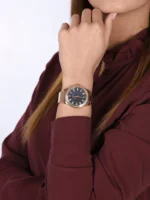 Montre Guess GW0111L3 Sparkler femme portée au poignet avec une chemise bordeaux, lunette sertie de cristaux