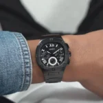 Montre Guess GW0572G3 Headline noire portée au poignet d'un homme, à côté d'une manche en jean