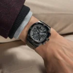 Montre Guess GW0572G5 Headline homme portée au poignet avec un pull en maille, cadran gris et chiffres romains