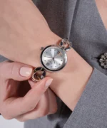 Montre Guess GW0759L1 femme argentée portée au poignet, bracelet à maillons G, avec une veste grise