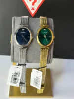 Montres Guess GW0935L1 argentée et GW0935L2 dorée côte à côte sur présentoir, cadrans sombre et vert