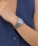 Montre Guess GW0936L1 femme portée au poignet avec un gilet bleu, cadran bleu glacier et bracelet acier