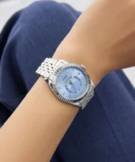 Montre Guess GW0936L1 femme au poignet, gros plan sur le cadran bleu glacier et la lunette cannelée argentée