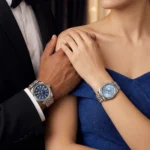 Couple en tenue de soirée, smoking et robe bleue, portant les montres Guess GW0977G1 homme et GW0936L1 femme
