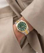 Montre Guess GW0977G4 Jaden homme au poignet, main dans la poche d'un costume beige, cadran vert et lunette dorée