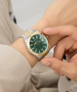 Montre Guess GW0977G4 Jaden homme portée au poignet et réglée à la main, cadran vert et bracelet argent et or