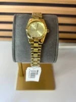 Michael Kors MK4951 posée sur un coussin présentoir gris avec son étiquette, bracelet acier doré à maillons