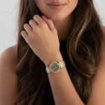 Femme portant la montre Michael Kors MK7394 au poignet, main près du visage, bracelet doré et cadran léopard