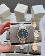 Montre Michael Kors MKO1049 femme posée sur son coussin dans sa boîte, cadran bleu et lunette sertie de cristaux
