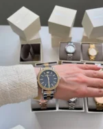 Montre Michael Kors MKO1049 femme portée au poignet, cadran bleu nuit, lunette dorée pavée et bracelet bicolore